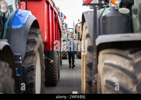 Argenteuil, France. 29 janvier 2024. Un jeune agriculteur est vu au milieu des tracteurs pendant la grève des agriculteurs. Suite à la grève des agriculteurs français, le début de la semaine a été marqué par le blocage de huit des principaux points d'accès à la capitale française. A Argenteuil, au nord de Paris, environ 30 tracteurs bloquent l'autoroute A15. (Photo Telmo Pinto/SOPA Images/Sipa USA) crédit : SIPA USA/Alamy Live News Banque D'Images