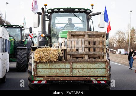 Argenteuil, France. 29 janvier 2024. Un agriculteur est vu conduire un tracteur pendant la grève des agriculteurs. Suite à la grève des agriculteurs français, le début de la semaine a été marqué par le blocage de huit des principaux points d'accès à la capitale française. A Argenteuil, au nord de Paris, environ 30 tracteurs bloquent l'autoroute A15. (Photo Telmo Pinto/SOPA Images/Sipa USA) crédit : SIPA USA/Alamy Live News Banque D'Images