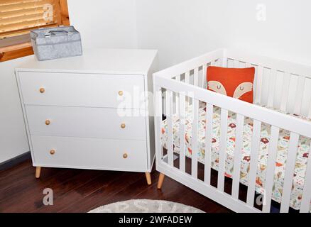 Un ensemble de meubles pour bébé d'une commode blanche et d'un lit d'enfant Banque D'Images