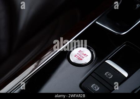 Démarrer le bouton d'arrêt du moteur intérieur de la voiture de luxe moderne. Détails du changement de vitesse de transmission automatique, système de contrôle multimédia, panneau de commande de voiture, bouton d'urgence rouge de vent d'air et tableau de bord à l'intérieur. Voiture de sport de prestige. Mise au point sélective Banque D'Images