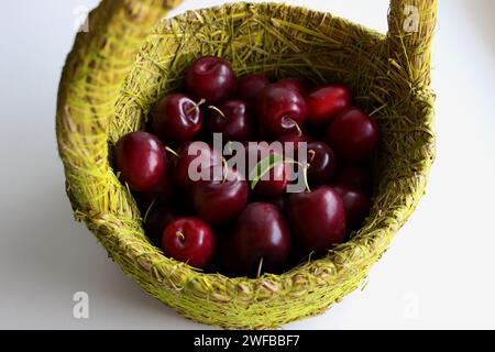 Panier en osier avec prunes rouges mûres vue du dessus photo stock Banque D'Images