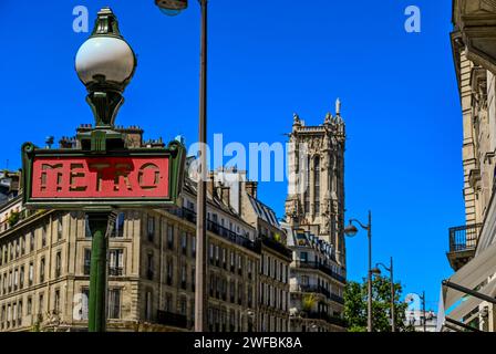 Paris, France, juin 2022. Belle photo mettant en évidence le panneau rouge du métro avec le lampadaire caractéristique. La Tour Saint-Jacques peut être vue dans le bac Banque D'Images