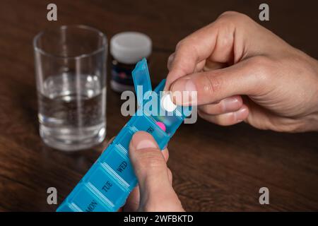 Homme prendre des pilules de la boîte. Santé et concept de vieillesse avec les médicaments. Médicaments sur table Banque D'Images