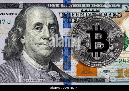 Pièce symbolique en argent Bitcoin sur des billets de cent dollars. Échangez bitcoin cash contre un dollar. Crypto-monnaie sur les billets de dollar américain. Mode numérique Banque D'Images