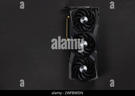 Grande et puissante carte graphique avec trois ventilateurs sur fond sombre. vue de dessus Banque D'Images
