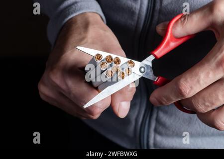 Cesser de fumer. Gros plan des mains d'homme tenant un bouquet de cigarettes et les coupant en deux avec des ciseaux. Arrêter de fumer la cigarette concept. Banque D'Images