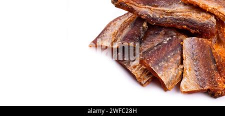 Morceaux de poisson séché nettoyé isolé sur blanc. Pollack sec et poivré. Ambrer avec du poivre. Banque D'Images