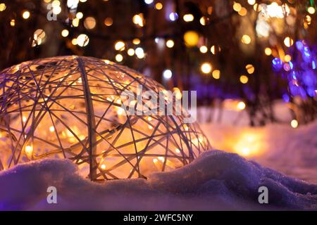 Boule décorative avec guirlandes sur le fond des lumières de Noël dans la rue la nuit Banque D'Images