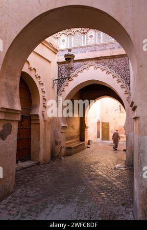 Afrique du Nord Maroc Marrakech Marrakech Médina arches l'homme marocain dans la rue avec des vêtements habillés traditionnels marchant dans la rue étroite vide Banque D'Images