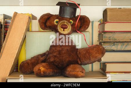 Pile de livres avec ours en peluche portant un chapeau de graduation.Learning, éducation, connaissance est puissance, diplôme d'études supérieures et concept de retour à l'école. Banque D'Images