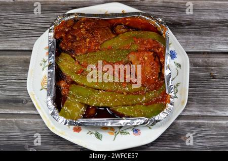 Aubergine rôtie marinée et poivrons verts farcis à l'ail, piment rouge, vinaigre, citron, coriandre, persil, tomates et épices hachées, Banque D'Images