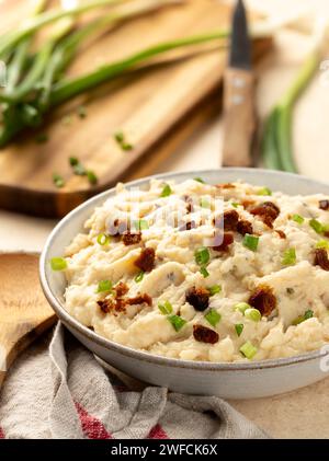 Purée de pommes de terre avec bacon et oignon vert dans un bol blanc Banque D'Images