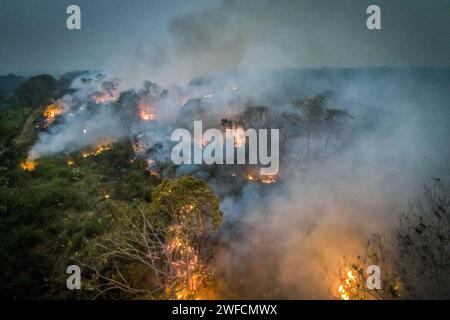 Vue depuis un drone brûlé dans une zone de forêt tropicale amazonienne au crépuscule pour ouvrir des pâturages ou des plantations de céréales Banque D'Images