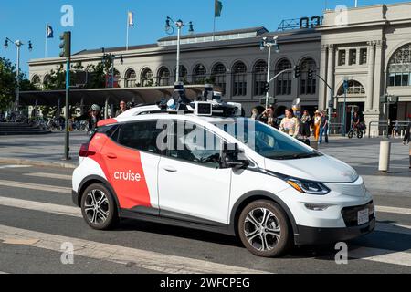 Une voiture autonome General Motors Cruise, souvent appelée robotaxi, conduit devant le Ferry Building sur l'Embarcedero, San Francisco, Californie, le 17 août 2023. Banque D'Images