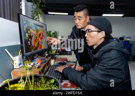 (240130) -- CHENGDU, 30 janv. 2024 (Xinhua) -- Deng Peilin (à gauche) discute des détails des lanternes avec un concepteur dans la ville de Zigong, dans la province du Sichuan, au sud-ouest de la Chine, le 19 janvier 2024. Le projet national de patrimoine culturel immatériel Zigong Lantern show possède une longue histoire. Elle remonte aux dynasties Tang (618-907) et Song (960-1279). Deng Peilin, né dans les années 1970, est un artisan éminent des lanternes Zigong. Il a appris des artisans renommés pendant des années pour apprendre les compétences de la conception et de la fabrication de lanternes. Deng a été témoin du développement de l'industrie de lanterne Zigong au cours de TH Banque D'Images