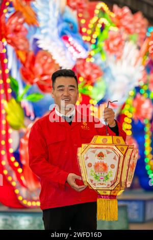 (240130) -- CHENGDU, 30 janv. 2024 (Xinhua) -- Deng Peilin pose avec une lanterne Zigong traditionnelle dans la ville de Zigong, dans la province du Sichuan, au sud-ouest de la Chine, le 19 janvier 2024. Le projet national de patrimoine culturel immatériel Zigong Lantern show possède une longue histoire. Elle remonte aux dynasties Tang (618-907) et Song (960-1279). Deng Peilin, né dans les années 1970, est un artisan éminent des lanternes Zigong. Il a appris des artisans renommés pendant des années pour apprendre les compétences de la conception et de la fabrication de lanternes. Deng a été témoin du développement de l'industrie des lanternes Zigong au cours des deux derniers décembre Banque D'Images