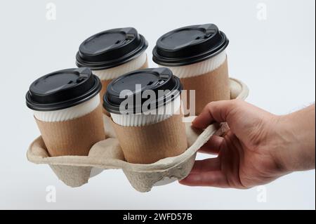 Thème de la livraison de café. 4 gobelets en papier avec couvercles chauds dans le plateau en carton Banque D'Images