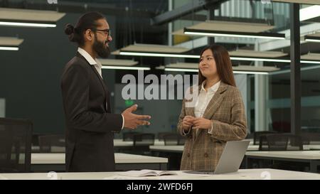 Femme d'affaires asiatique travailleuse coréenne femme gestionnaire parlant avec l'homme d'affaires arabe dirigeant indien PDG deux collègues d'affaires bureau parlant Banque D'Images