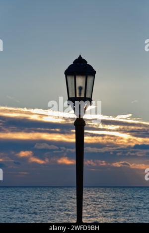 Gros plan d'un vieux lampadaire orné contre un coucher de soleil hivernal au crépuscule Banque D'Images