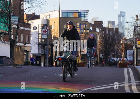 Les cyclistes font la navette à Hackney sous le soleil d'hiver tôt le matin le 26 janvier 2024, Londres, Royaume-Uni. Banque D'Images