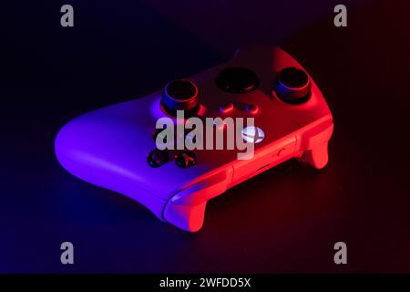 Dnipro, Ukraine, 02 octobre 2023 : manette de jeu Xbox Series S sur sombre. Lumière rouge et bleue. Banque D'Images