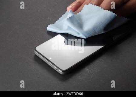 Elimination des germes. Nettoyage de l'écran du smartphone avec un chiffon en fibre de la poussière de saleté et d'autres facteurs externes. Concept Mobile Care Banque D'Images