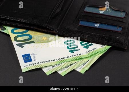Les euros sortent du portefeuille. Billets en papier de 100 euros chacun. Symbole pour les dépenses croissantes, l'inflation, payer les factures des ménages, salaire, bonus, wi Banque D'Images