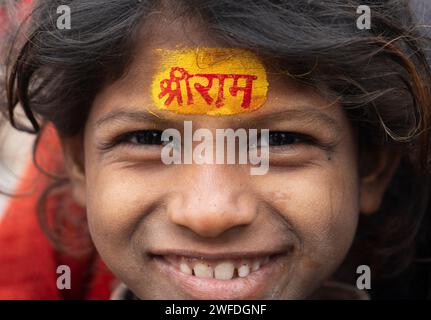 Les enfants se font peindre le nom du seigneur hindou Shri RAM sur leur front, à Ayodhya, Uttar Pradesh, Inde, le 21 janvier 2024. Banque D'Images