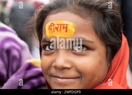 Les enfants se font peindre le nom du seigneur hindou Shri RAM sur leur front, à Ayodhya, Uttar Pradesh, Inde, le 21 janvier 2024. Banque D'Images