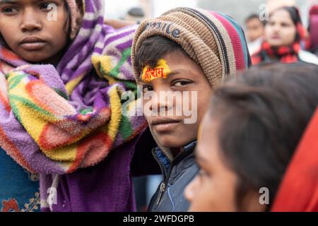 Les enfants se font peindre le nom du seigneur hindou Shri RAM sur leur front, à Ayodhya, Uttar Pradesh, Inde, le 21 janvier 2024. Banque D'Images