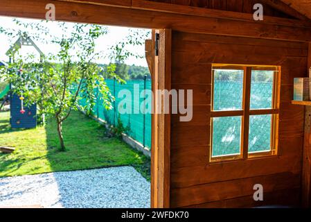 Un abri de jardin en bois debout sur une fondation en béton dans un jardin, vue de l'intérieur de la maison. Banque D'Images