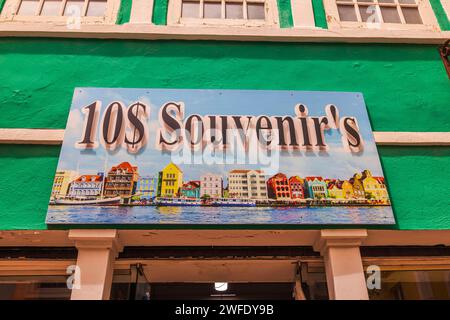 Vue d'une peinture vibrante au-dessus de l'entrée d'une boutique de souvenirs présentant des produits bon marché, représentant les façades colorées de Willemstad, Curaçao. Banque D'Images