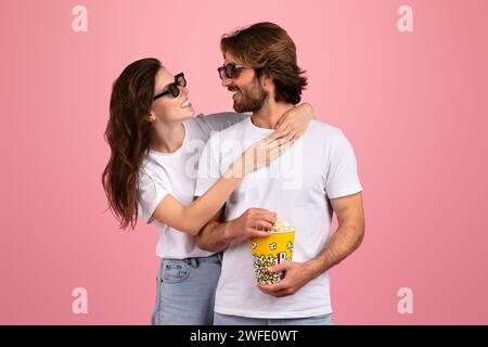 Un couple joyeux en t-shirts blancs et lunettes de soleil partageant un moment de rire Banque D'Images