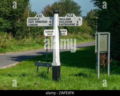 Attrayant vieux, traditionnel, vintage panneau de route en bois avec lettrage peint noir sur fond blanc au carrefour sur l'A22 près d'Uckfield Banque D'Images