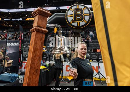 Femme sonnant la cloche à la ligne d'arrivée du 8e BFit Challenge annuel, organisé par la Boston Bruins Foundation. Banque D'Images