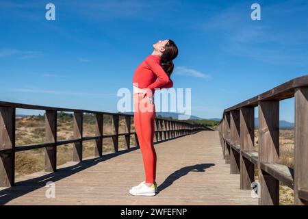 Femme coureuse sur une promenade tenant son dos, mal de dos pendant le sport. Banque D'Images