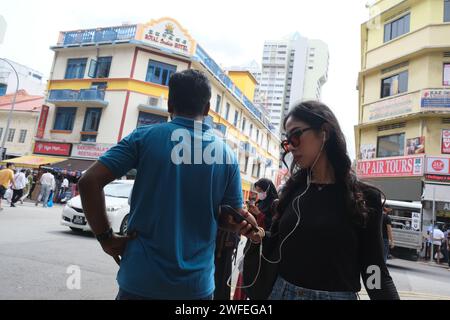 Une femme chinoise passe devant un Indien dans le quartier animé de Little India à Singapour Banque D'Images