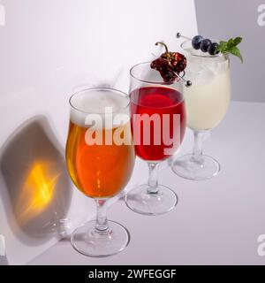 Cocktails et bière préparés et garnis dans le studio sur fond blanc Banque D'Images