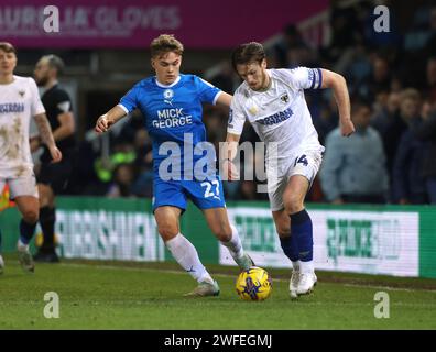 Peterborough, Royaume-Uni. 30 janvier 2024. Archie Collins (pu) Armani Little (AFCW) au Peterborough United vs AFC Wimbledon EFL Trophy Match, au Weston Homes Stadium, Peterborough, Cambridgeshire, le 30 janvier 2024. Crédit : Paul Marriott/Alamy Live News Banque D'Images