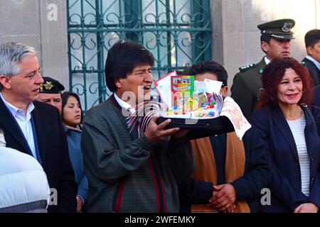 La Paz, BOLIVIE ; 24 janvier 2015. Le président bolivien Evo Morales tient une valise miniature pleine de billets de banque (cadeau des artésiens) lors d’un événement marquant le début du festival Alasitas à la Paz. Au festival, les gens achètent des miniatures de ce qu'ils veulent obtenir au cours de l'année et les font bénir pour que leurs souhaits deviennent réalité. Les miniatures populaires disponibles comprennent des voitures, des maisons, de l'argent, des certificats de diplôme, des valises et des passeports (pour voyager). Banque D'Images