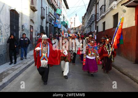 La Paz, BOLIVIE ; 24 janvier 2015. Les chamans aymaras portant des coquilles de conque marchent devant une ancienne illa (ou statue) d'un Ekeko (un dieu aymara de l'abondance) alors qu'il défile dans les rues de la Paz pour célébrer sa première apparition au festival Alasitas, qui commence aujourd'hui. La statue a environ 2000 ans et a été faite par la culture Pucara. Il a été pris du site archéologique de Tiwanaku en Suisse en 1858, et retourné à la Bolivie par le Musée d'histoire de Berne en novembre 2014. Banque D'Images