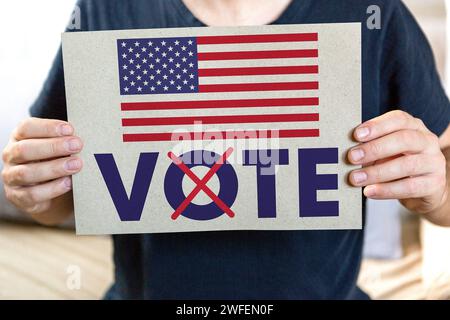 30 janvier 2024 : élection présidentielle aux États-Unis d'Amérique, Un homme tient un vote par affiche électorale en Amérique PHOTOMONTAGE *** Präsidentschaftswahl in den Vereinigten Staaten von Amerika, Ein Mann hält ein Wahlplakat in der Hand vote in America FOTOMONTAGE Banque D'Images