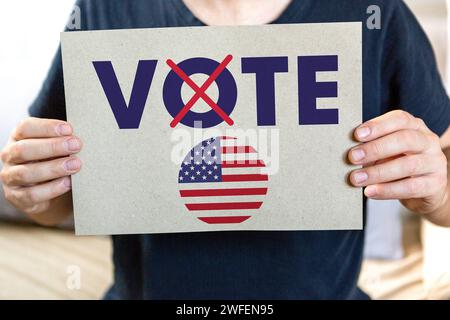 30 janvier 2024 : élection présidentielle aux États-Unis d'Amérique, Un homme tient un vote par affiche électorale en Amérique PHOTOMONTAGE *** Präsidentschaftswahl in den Vereinigten Staaten von Amerika, Ein Mann hält ein Wahlplakat in der Hand vote in America FOTOMONTAGE Banque D'Images