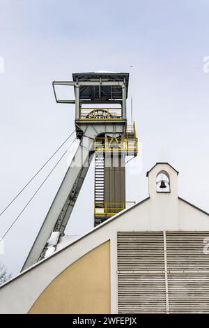 Un arbre de palan de mine contre un ciel gris. Gros plan des roues en haut de l'arbre. Banque D'Images