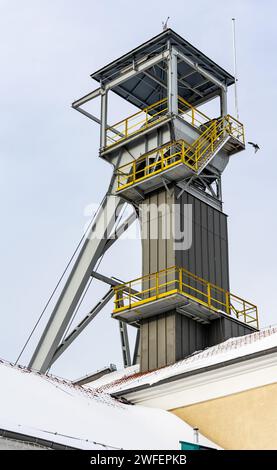 Un arbre de palan de mine contre un ciel gris. Gros plan des roues en haut de l'arbre. Banque D'Images