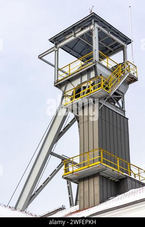 Un arbre de palan de mine contre un ciel gris. Gros plan des roues en haut de l'arbre. Banque D'Images