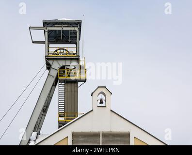 Un arbre de palan de mine contre un ciel gris. Gros plan des roues en haut de l'arbre. Banque D'Images