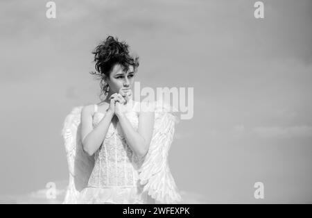 Saint Valentin ange adolescence priing. Ange adolescent, fille avec des ailes sur fond de ciel. Concept de la Saint-Valentin. Ange adolescent dans le ciel. Banque D'Images