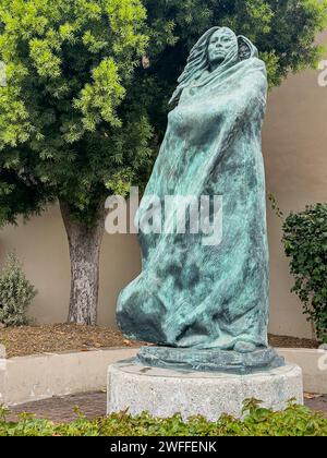 Santa Barbara, CA, États-Unis - 19 janvier 2024 : statue en bronze vert de Juana Maria et de Child closeup. Feuillage vert à l'arrière. Femme solitaire de San Nicolas Isla Banque D'Images