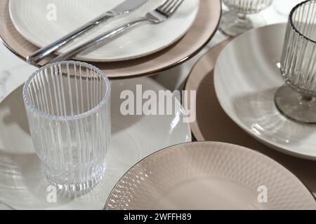 Assiettes en céramique élégantes, couverts et verres sur la table, gros plan Banque D'Images